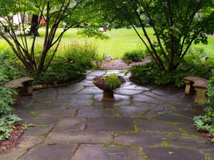 Paver patio with fire pit and seating wall in a St. Johns County FL backyard